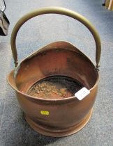 A copper helmet shaped coal scuttle, with brass ring handle.