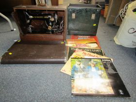 A cased Singer sewing machine, together with various LP records.