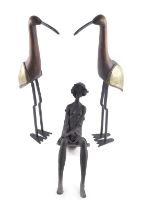 Unmarked sculptures, comprising a pair of sculptured and wooden birds, on metal legs, 51cm high, and