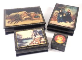 Four Russian black lacquer boxes, decorated with a cat, church, two figures and dog, and a transfer