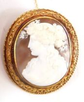 A 19thC shell cameo brooch, the oval cameo depicting maiden in flowing gown with floral headdress, i