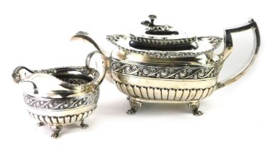 A George IV Irish silver teapot and jug, each with part fluted decoration and a band of scrolls, flo