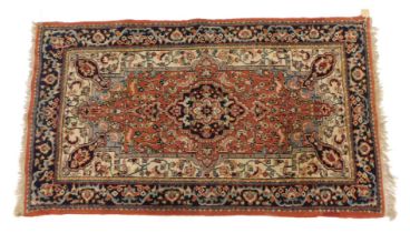 An Eastern rug, on an orange ground with medallions, 159cm x 90cm.