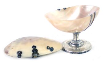 A George V mother of pearl shell salt, mounted in silver, Chester 1923, and a brass and mother of pe