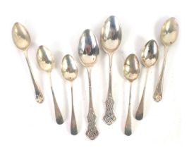 Eight silver spoons, comprising two silver golf topped tea spoons, a match set of four tea spoons, a