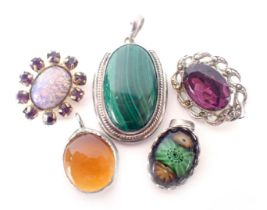 A group of costume brooches and pendants, comprising a malachite pendant in white metal frame stampe