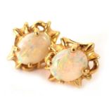 A pair of opal stud earrings, each with oval opal with outer abstract flow border, on single pin bac