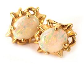 A pair of opal stud earrings, each with oval opal with outer abstract flow border, on single pin bac