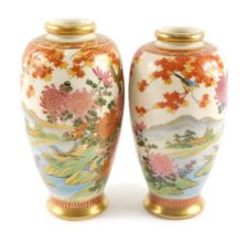 A pair of 19thC Japanese Imperial Satsuma vases, with a gilded rim and painted blossoms, buildings a