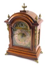 A late 19thC walnut and gilt metal German mantel clock, the top applied with flame finials, etc., wi
