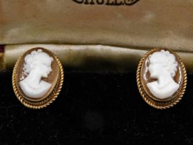 A pair of shell cameo earrings, each with oval cameo in rope twist bordered setting, in earring moun