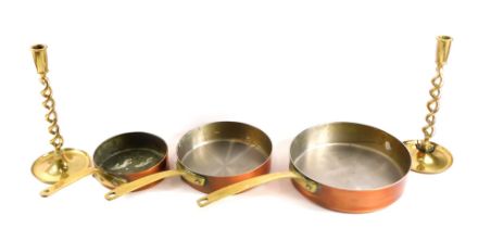 Copper and brass wares, comprising a set of three copper and brass handled saucepans of graduated fo