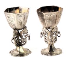 A pair of continental white metal miniature goblets, each of hexagonal form with etched floral decor