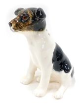 A Winstanley dog, seated on a white ground with brown mottling and amber eyes, 23cm high.