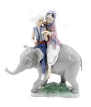 A Lladro figure group, of girl and boy seated atop an elephant, 22cm high.