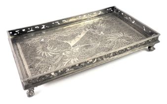 An eastern pewter rectangular card tray, with decoration of dragons, on a pierced border with ball a