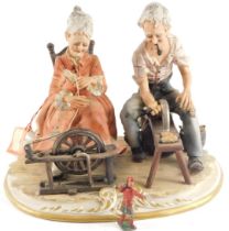 A Capodimonte style figure group, of lady and gentleman sewing, on a circular foot, 20cm high.