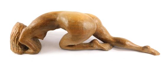 A carved wooden figure of a kneeling nude female, 55cm wide.