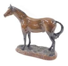 A Melrose china brown shire horse, on a stepped foot, 30cm high, 26cm wide.