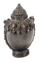 An eastern white metal scent bottle, with applied scroll and semiprecious stone detail on a horn bod