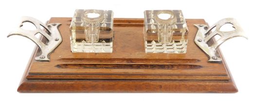 An Art Nouveau style oak desk stand, with two silver plated handles, with heart shaped thumb piece,