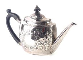 A George III silver teapot, with later embossed floral and scroll design, with central shield bearin