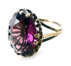 An amethyst dress ring, set with oval amethyst in four double claw setting with petalated border on
