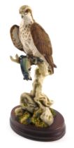 A Sheraton and Simpson figure group of a perched falcon with fish, numbered 127, 39cm high.