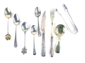 Assorted silver and white metal cutlery, comprising souvenir spoons, Carlisle with enamel top, a fid
