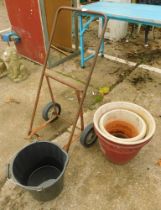 A metal push along trolley, two terracotta planters and a bucket.