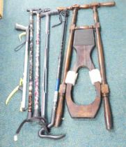 A group of walking and hiking sticks, and a boot pull.