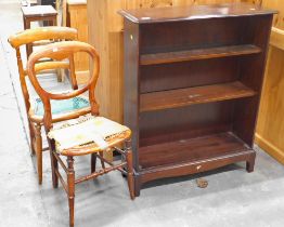 Two cane side chairs and a Stag mahogany bookshelf.