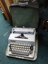 An Adler cased typewriter and cushion pad.