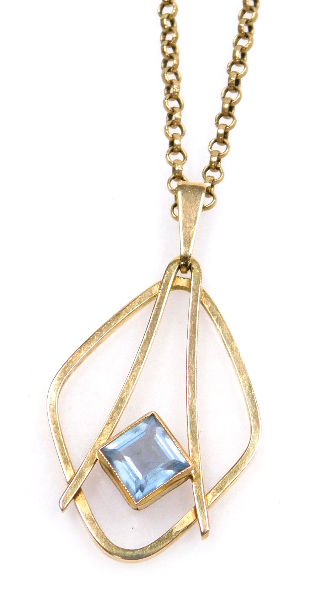 A modernist 9ct gold and pale blue gem set pendant, possibly a topaz, on a belcher link neck chain,