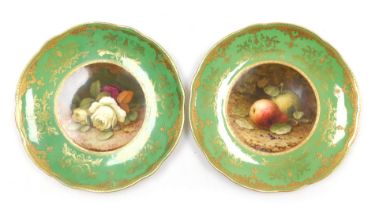 A pair of early 20thC Coalport porcelain cabinet plates, painted by F H Chivers, with fruit, and ros