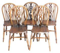A Harlequin set of five oak and elm wheel back dining chairs.