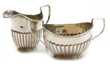 An Edward VII silver semi-fluted twin handled sugar bowl, Birmingham 1904, and a semi-fluted cream j