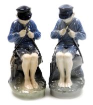 A pair of Royal Copenhagen porcelain figures of a boy, modelled seated whittling a stick, no. 905, p