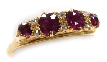 A ruby four stone ring, set with pairs of diamonds at intervals, in a claw mount, yellow metal, stam