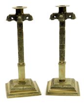 A pair of 19thC brass candlesticks, profusely engraved with flowers and scrolling leaves, raised on