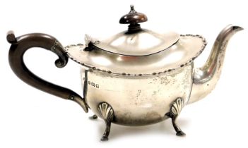 A George V silver teapot, with a piecrust border, raised on four hoof feet, Birmingham 1922, 10.35oz