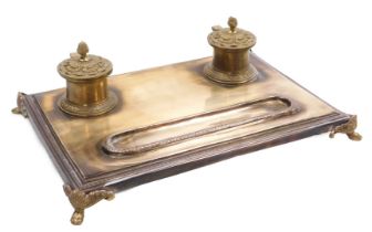 A late 19thC French polished bronze encrier, the pair of inkwells with floral embossed, hinged lids,