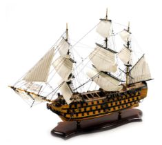 A wooden scale model of HMS Victory, raised on a wooden base, with plaque, 47cm wide.