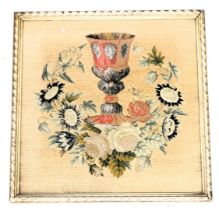 A Victorian beadwork and tapestry picture, of a chalice, within a wreath of roses and other flowers,