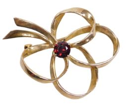 A 9ct gold and garnet brooch, of scrolling bow form, 6.2g.