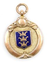 A 9ct two colour gold and enamel medallion, with a central shield showing three crowns, 7.1g.