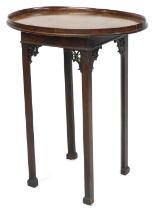 A Chippendale style mahogany night table, with an oval tray top, over a single candle slide, raised