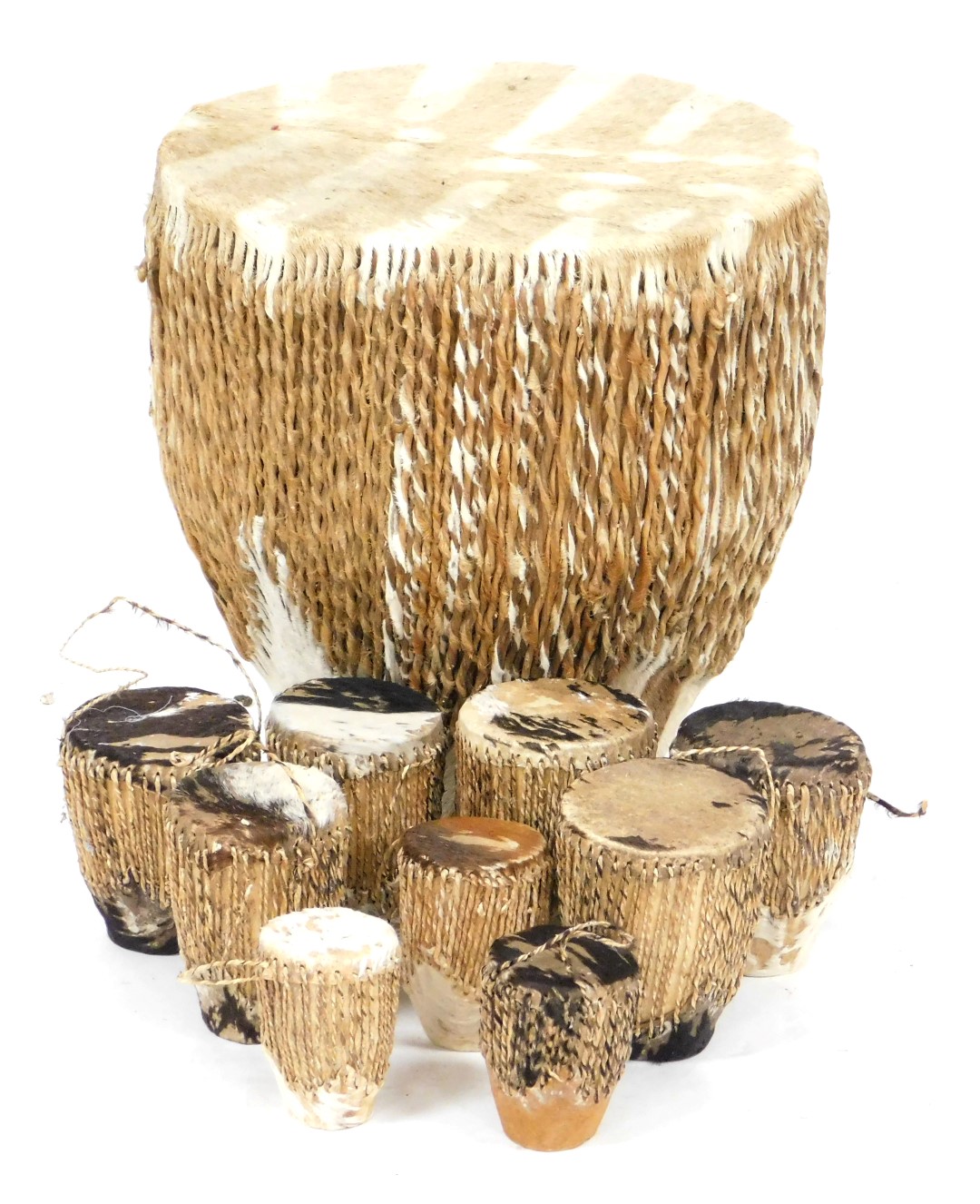 An African tribal hide drum, 35cm high, and nine small drums. (10)