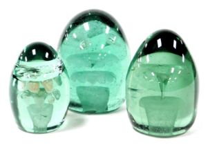 Three Victorian green glass dump paperweights, each decorated internally with flowers and a vase, o