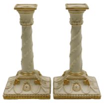 A pair of late 19thC Worcester porcelain candlesticks, converted for electricity, of white glazed co